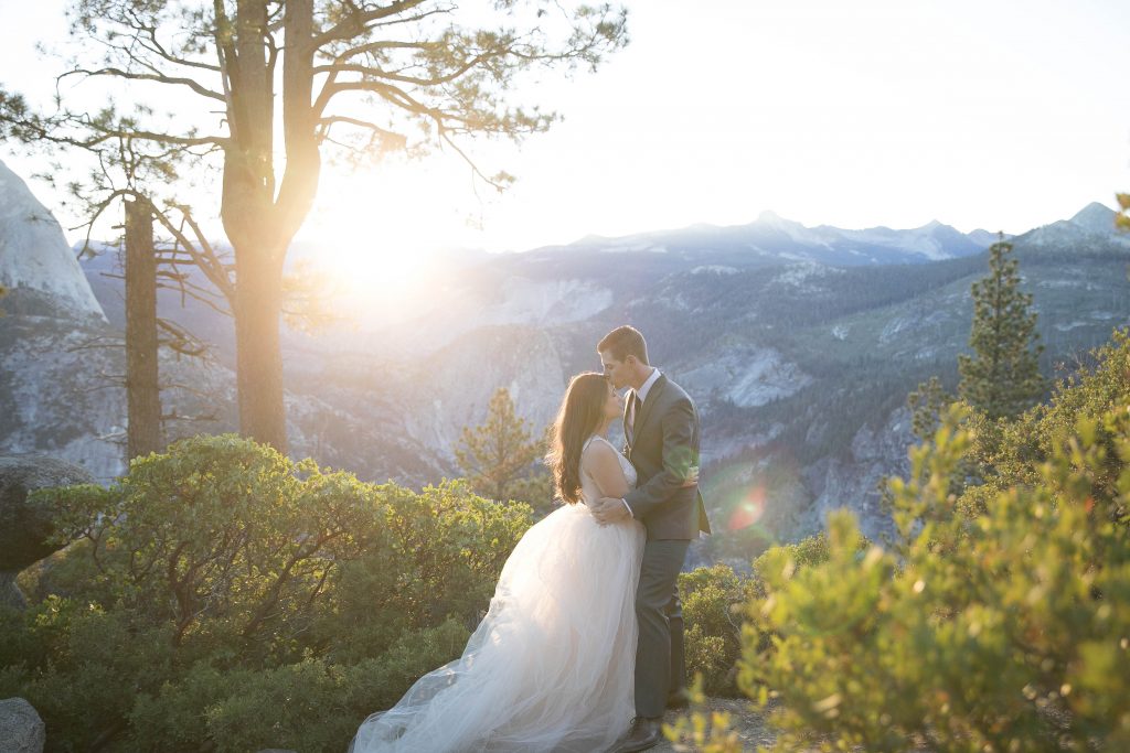 groom kisses bride on forehead in yosemite