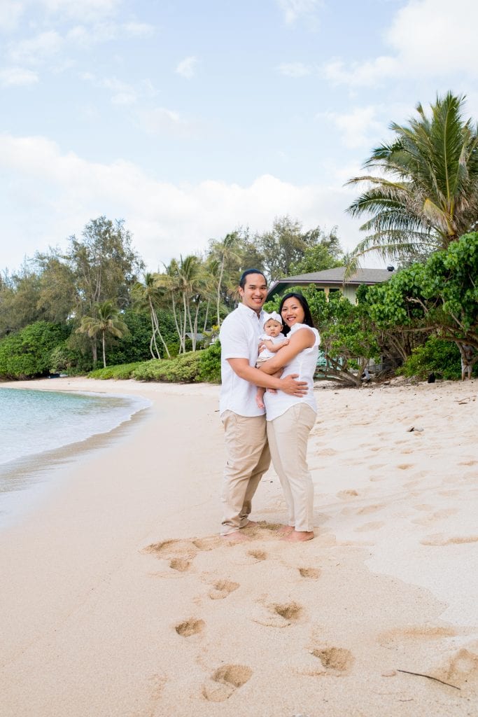 couple with baby hug on beach