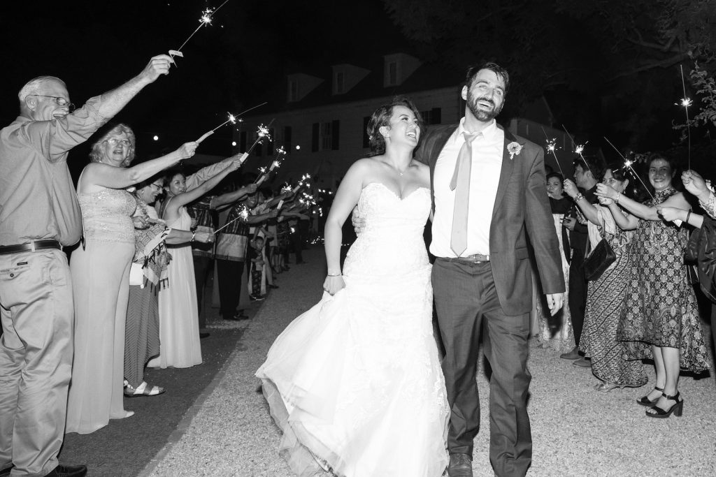 bride and groom smile during sparkler exit