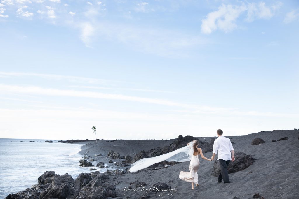 bride and groom hold hands along the beach after elopement