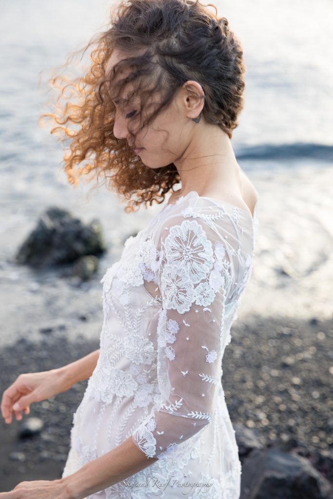 bride in wind Waikoloa, Hawaii with lace wedding dress