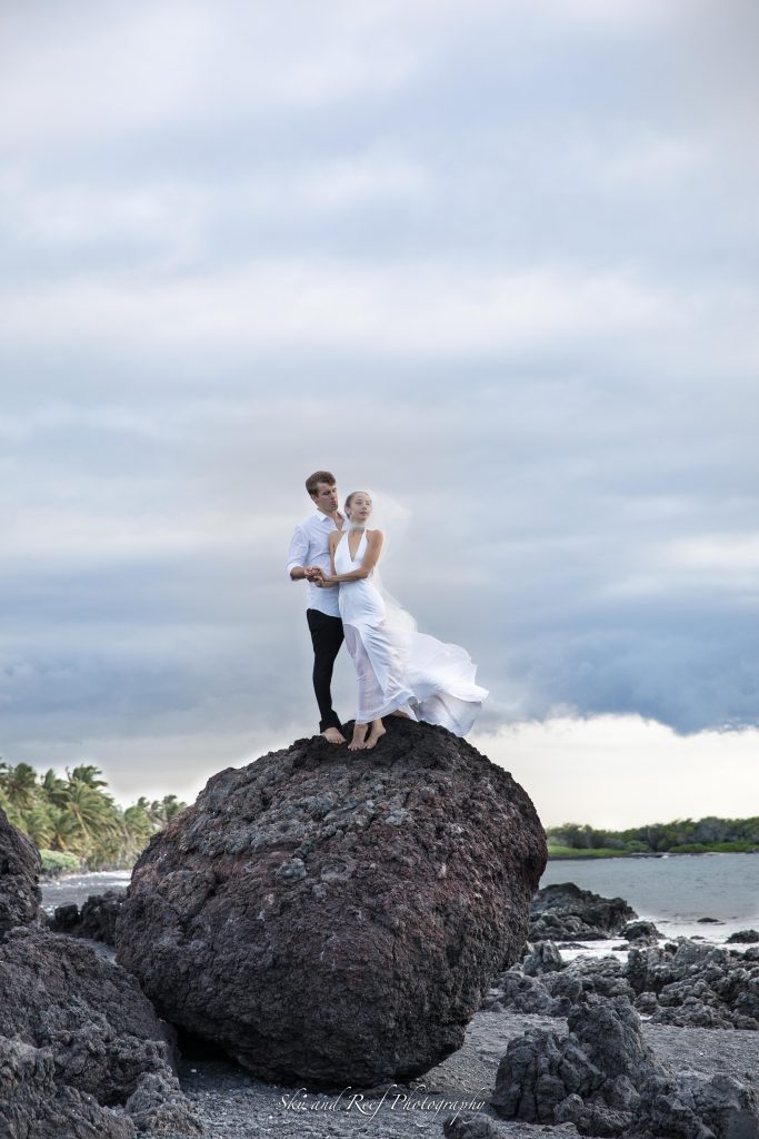 bride wears viel in wind on lava rock