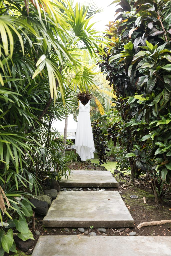 wedding dress hanging in tropical plants