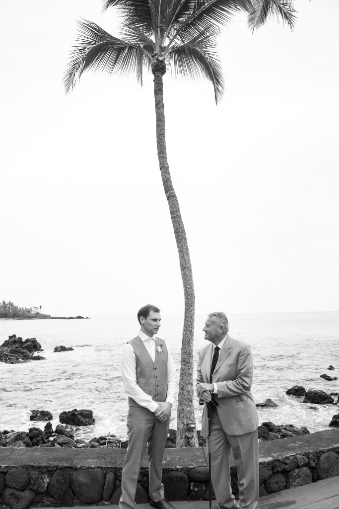 groom and father of bride talk after wedding under palm tree