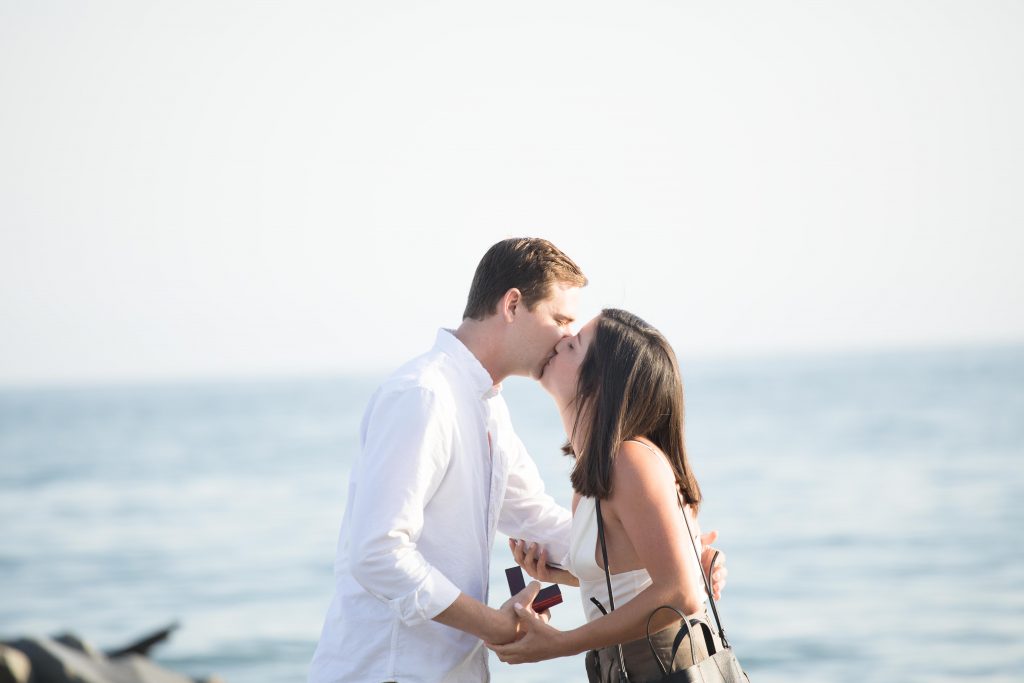 couple kiss after engagement in Malibu proposal