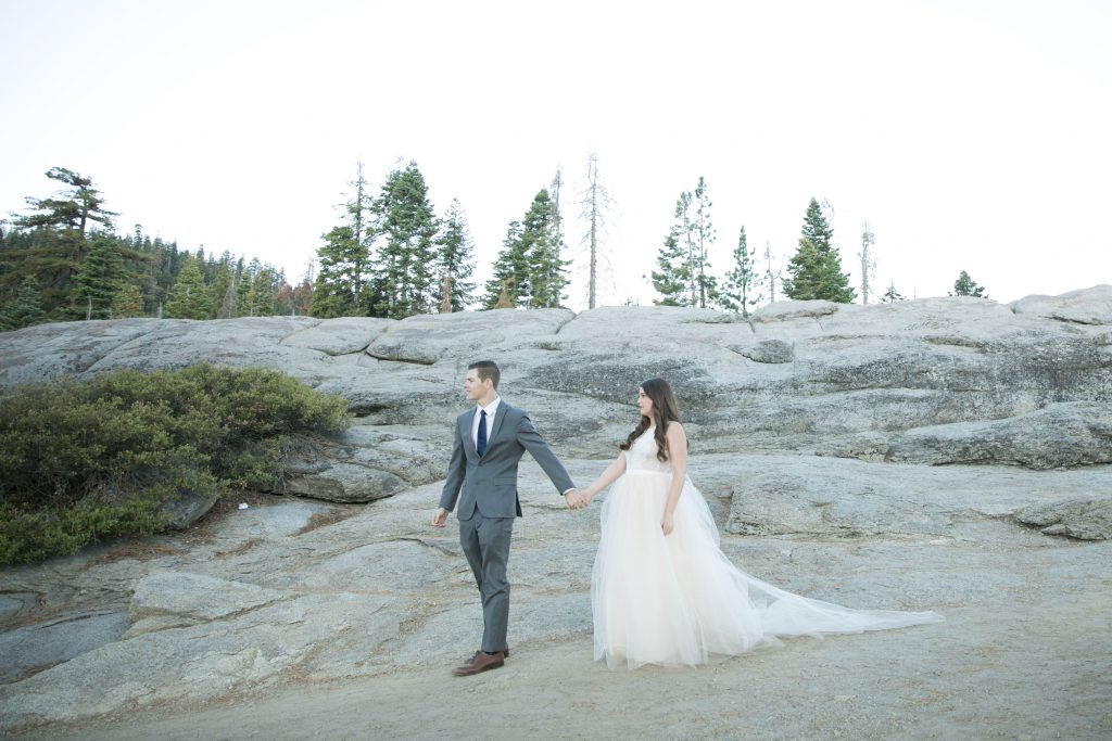 groom leads the way on the rocks yosemite wedding