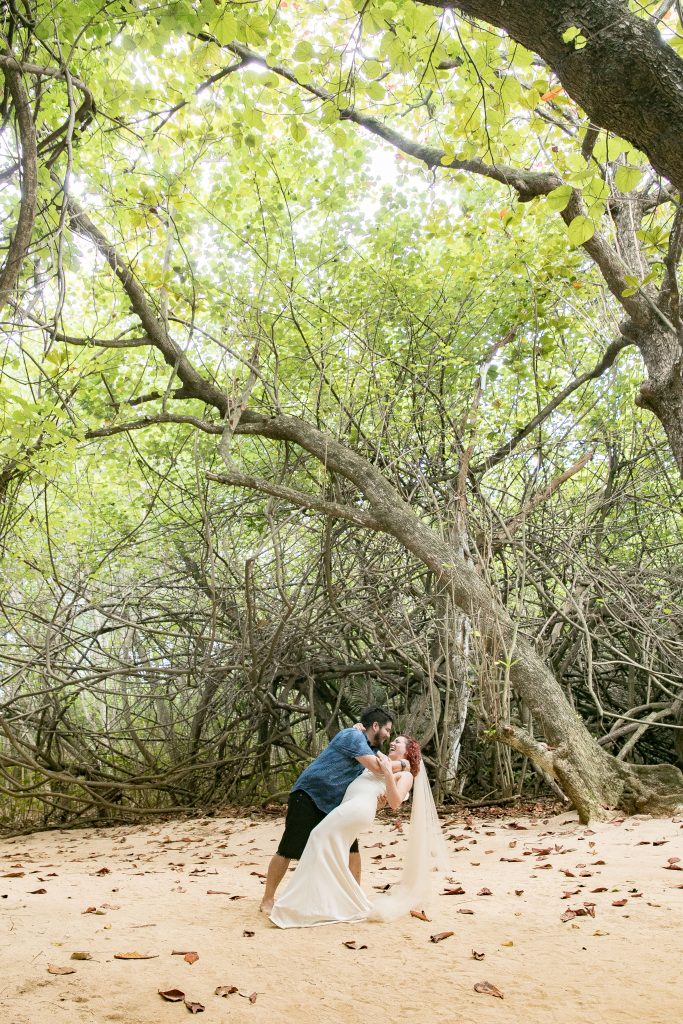 couple kiss under trees at wedding