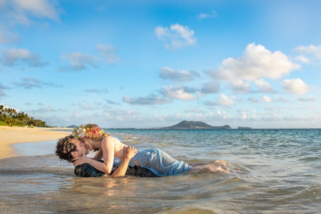 couple lay in sand for kiss